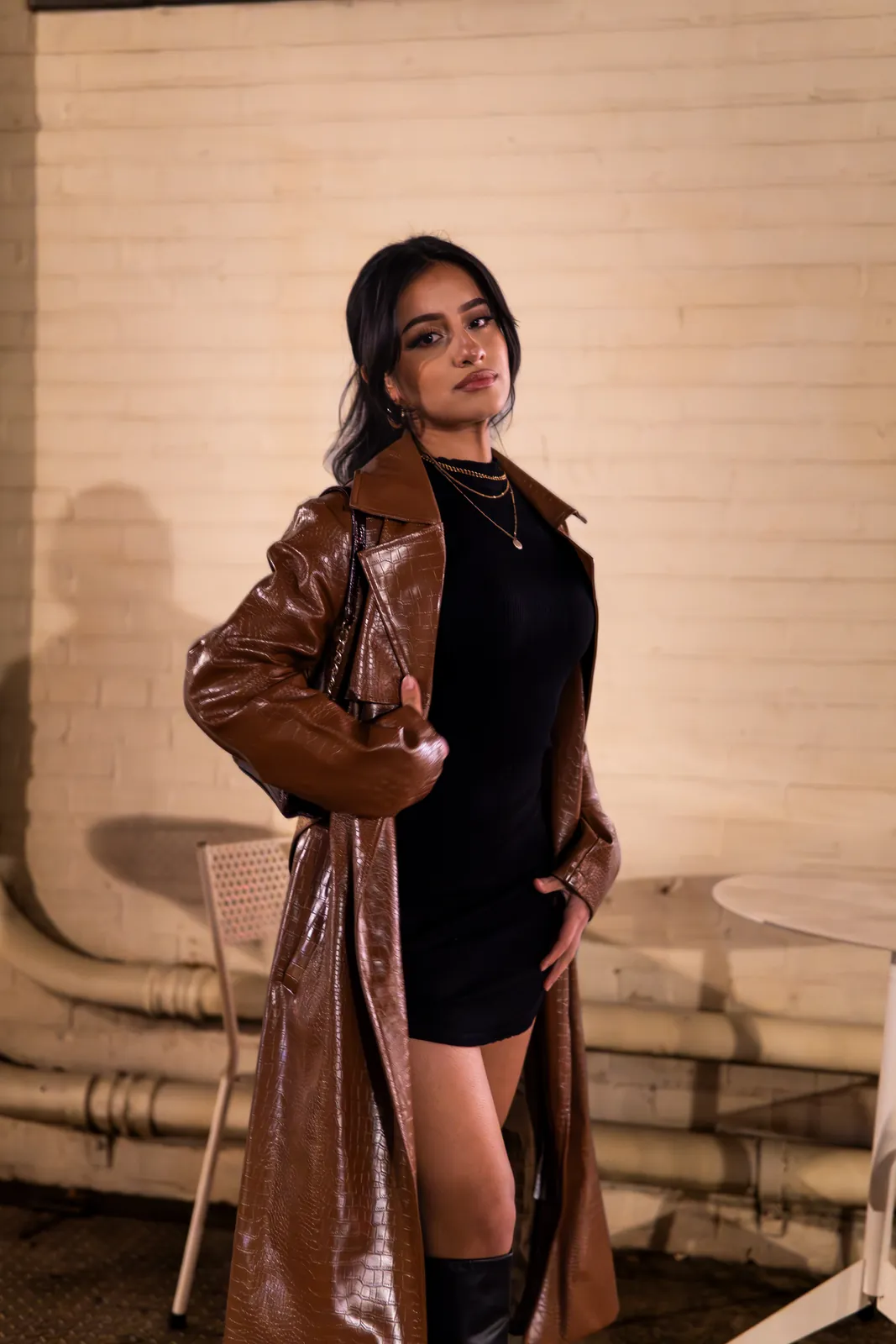 Portrait: woman in black dress and brown leather overcoat