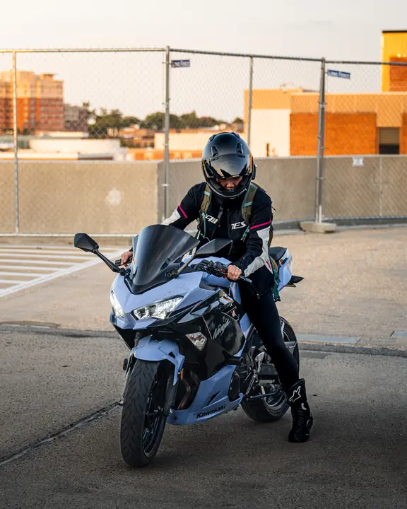 Woman parking her blue Kawasaki motorcycle
