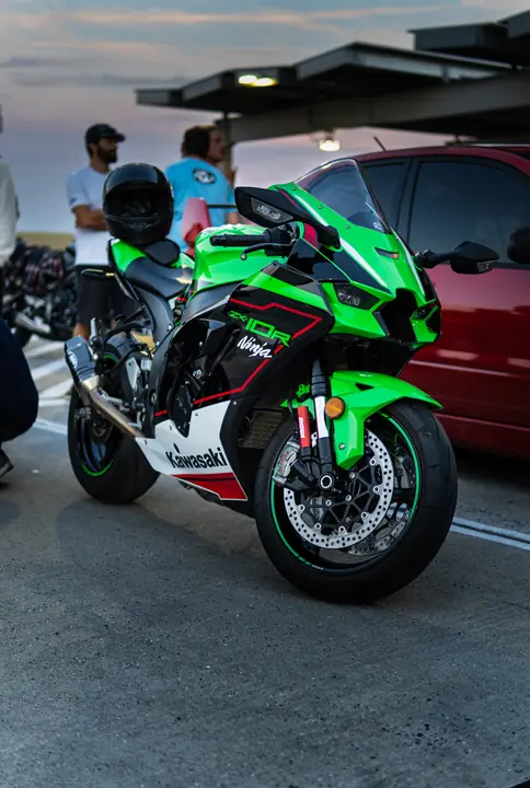 Green, black, and red Kawasaki Ninja ZX-10R on a parking garage