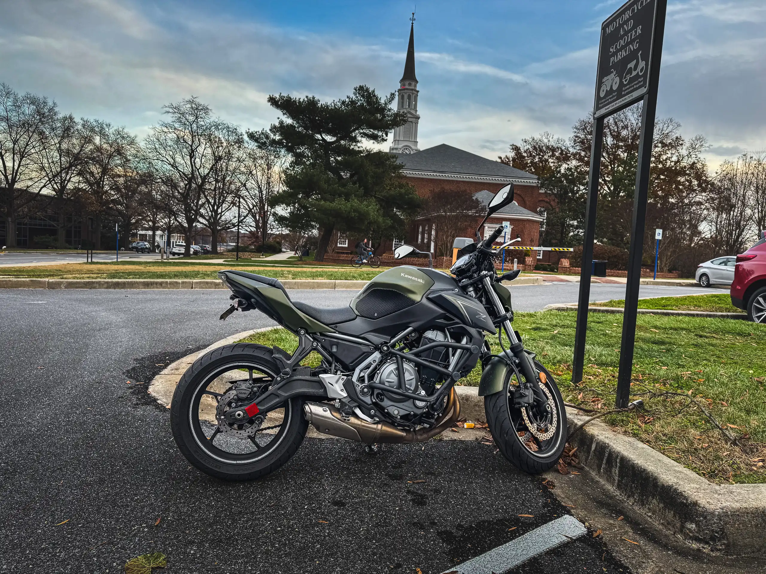 Dark green and black Kawasaki Motorcycle with chapel in background in parking lot in Maryland by Antlophotography